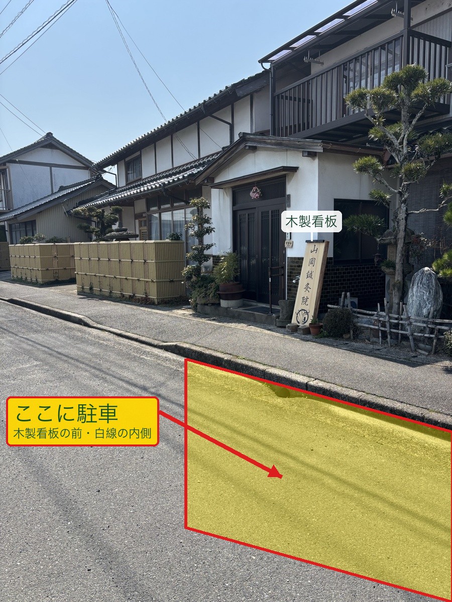 出張所(灘分町)の駐車位置を横から見た写真。木製看板の前の路肩(白線の内側)に駐車